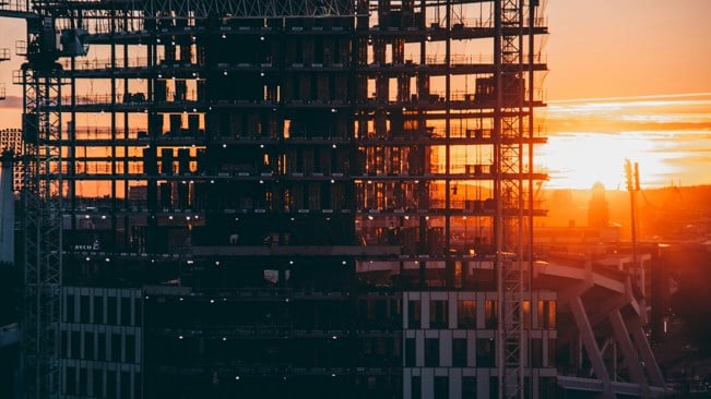 Siluett av en byggnadsställning mot en bakgrund av en solnedgång.